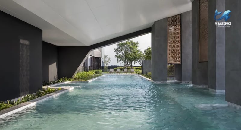 Indoor swimming pool with a contemporary design, surrounded by greenery and featuring lounge chairs.