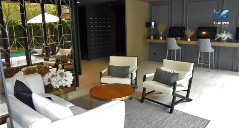 Comfortable lounge area with plush seating and a coffee table, adjacent to a co-working space.