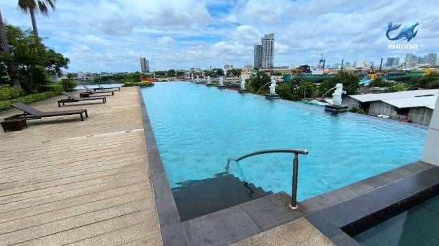 Infinity-edge swimming pool with sun loungers and panoramic city views