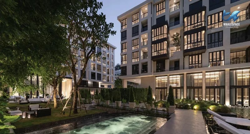 Beautifully landscaped communal garden with seating areas and mature trees, set against the backdrop of the modern condominium buildings.