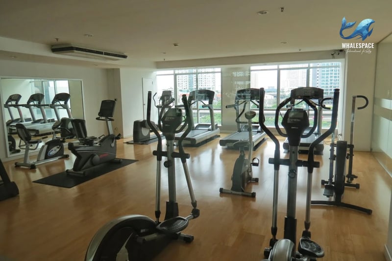 Spacious fitness center with modern cardio equipment and large windows offering a city view