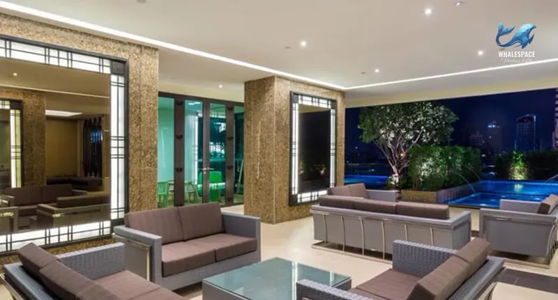 Luxurious indoor lounge area with plush seating, modern coffee tables, and ambient evening lighting overlooking a cityscape.