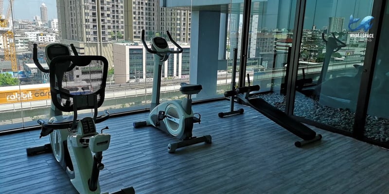 Fitness room with exercise bikes and city views through large windows