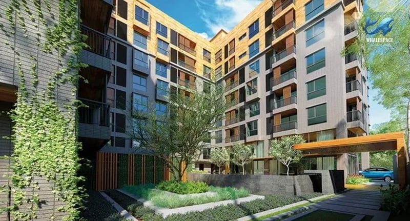 Modern apartment building with lush greenery and a covered entrance