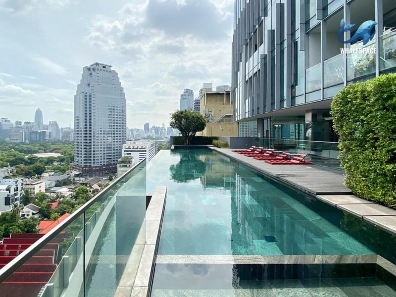 Rooftop infinity pool with city skyline views and sun loungers