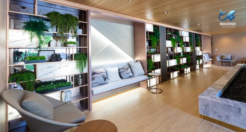 A stylish lounge area featuring a built-in sofa, decorative shelving with plants, and warm wood flooring.