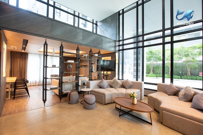 Grand double-height lobby with contemporary furnishings, large windows, and a sophisticated lounge area.