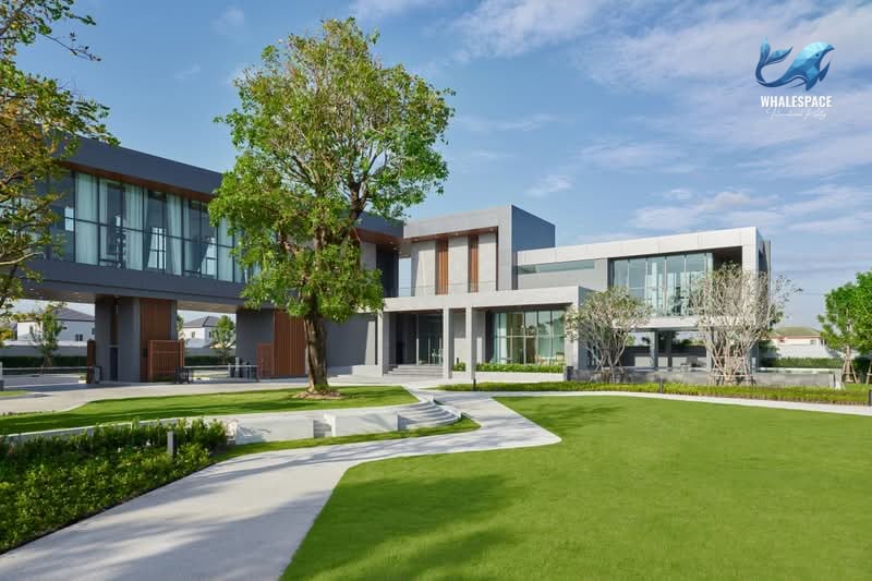 Modern multi-story house with large windows and manicured lawn