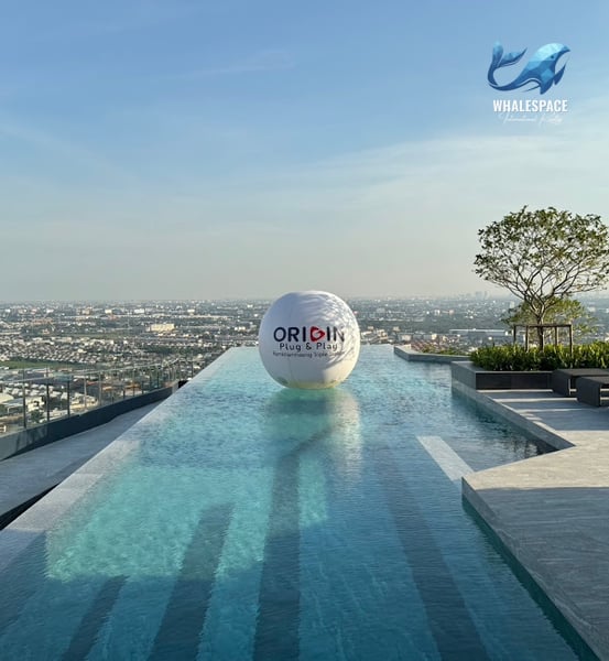 Stunning infinity pool with city views and a large branded sphere floating in the water.