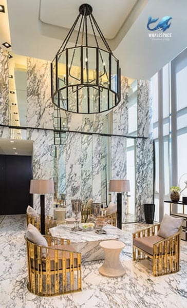 Elegant lobby featuring a dramatic multi-tiered chandelier, marble finishes, and plush seating arrangements, creating a luxurious first impression.