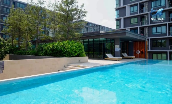 Serene swimming pool area with lounge chairs and lush greenery