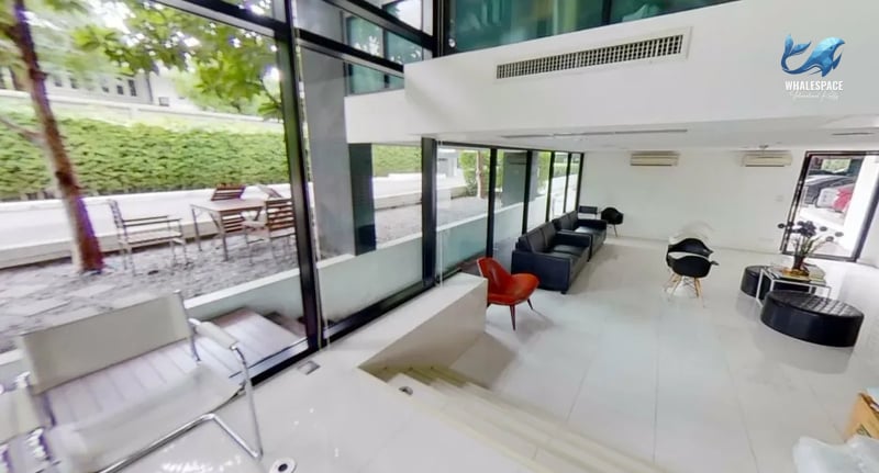 Stylish lounge area with comfortable seating arrangements and large windows overlooking an outdoor patio.