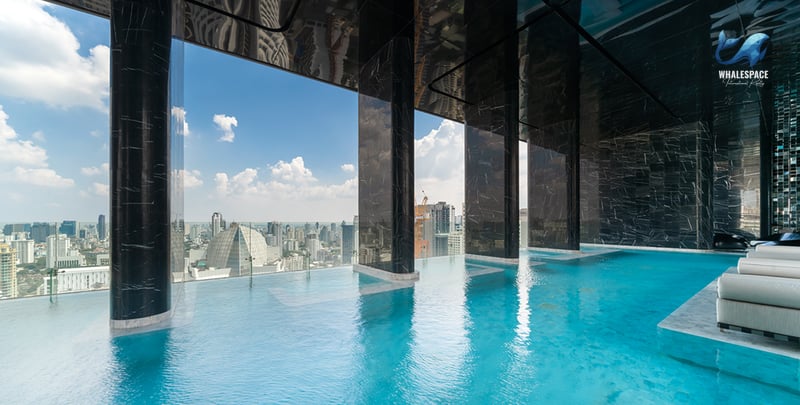 Infinity swimming pool with city views and lounge seating