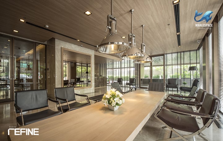 Modern coworking space with a long wooden table and contemporary pendant lighting