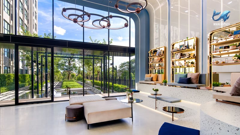 Modern lobby with comfortable seating, decorative lighting, and a view of lush garden landscaping