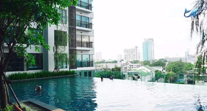 Infinity swimming pool with city views and people swimming
