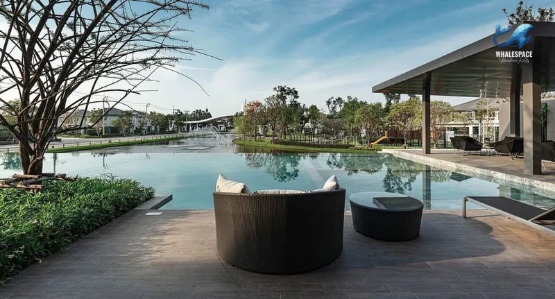Tranquil swimming pool with comfortable outdoor seating overlooking a lake