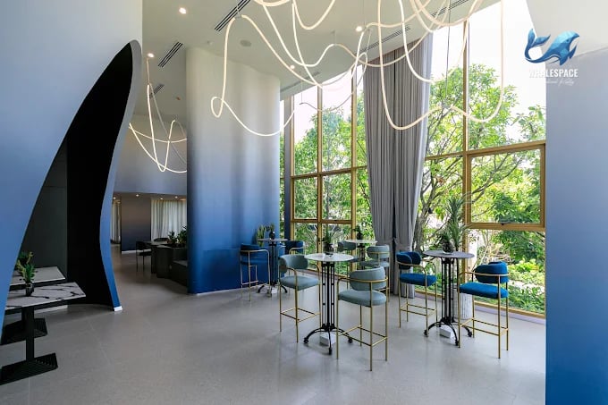 Stylish lounge area with high ceilings, modern lighting, and comfortable seating