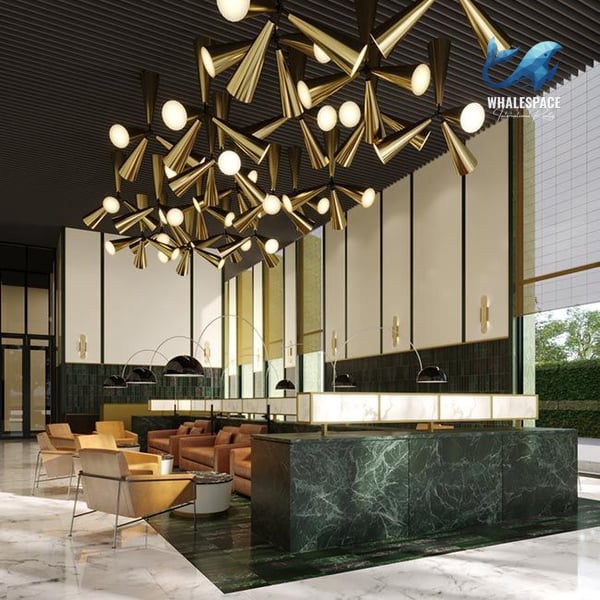 Grand double-height lobby with an intricate gold chandelier, marble reception desk, and luxurious seating areas.