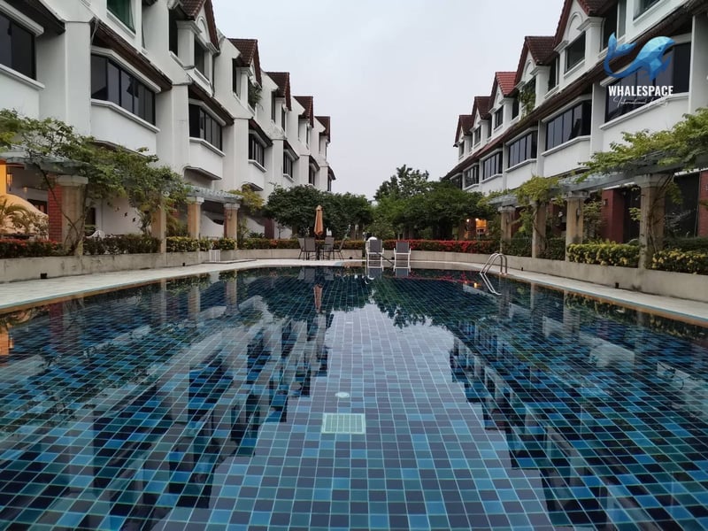 Expansive swimming pool with vibrant blue tiles reflecting the surrounding architecture