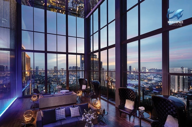 High-ceiling lounge area with panoramic city views and luxurious seating