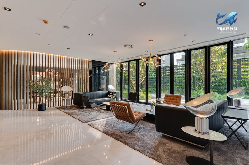 Elegant lounge space featuring contemporary furniture and floor-to-ceiling windows with garden views.