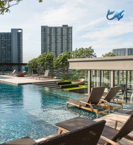 Expansive swimming pool with integrated lounge chairs and a backdrop of modern high-rise buildings, offering a serene oasis.