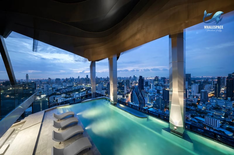 Infinity pool overlooking a sprawling cityscape at dusk
