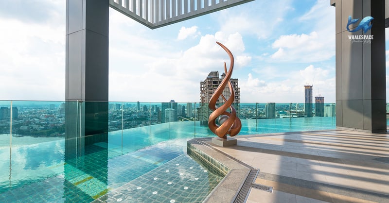 Infinity pool on rooftop with panoramic city views and a modern sculpture.