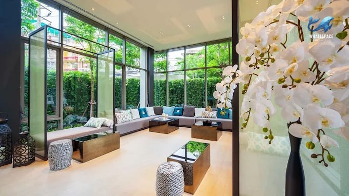 Elegant lounge area with plush seating and floor-to-ceiling windows offering garden views.