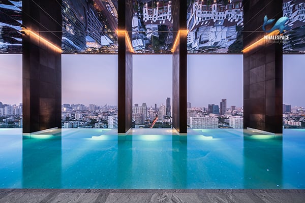 Infinity swimming pool with stunning city skyline views at dusk.