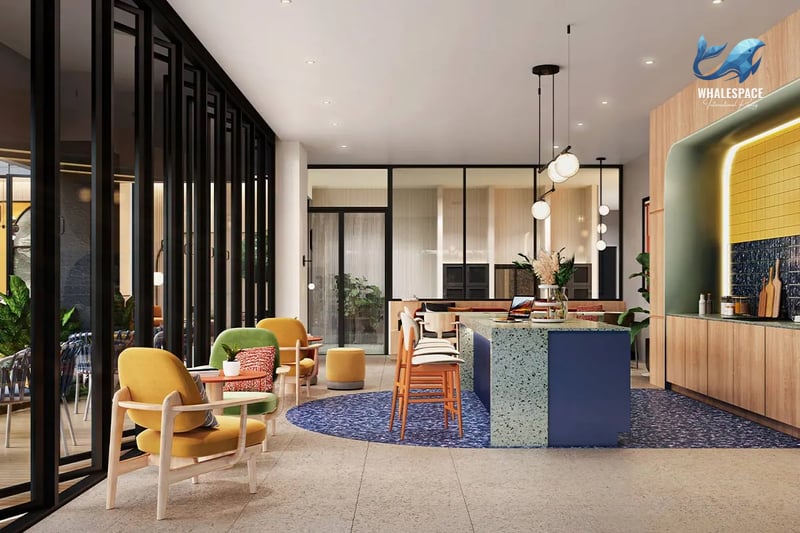 Vibrant communal lounge area with colorful seating, a modern kitchen island, and ample natural light.