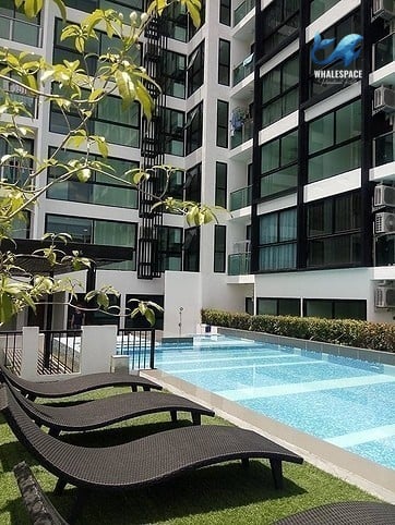 Serene pool area with sun loungers and modern building facade