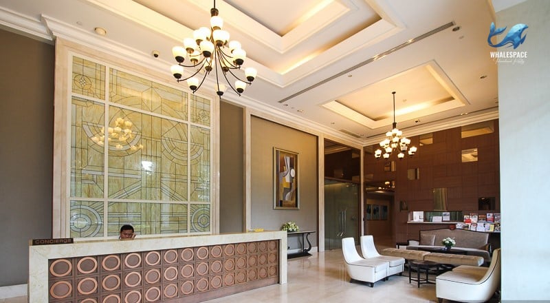 Grand lobby with a concierge desk, ornate chandelier, and marble flooring