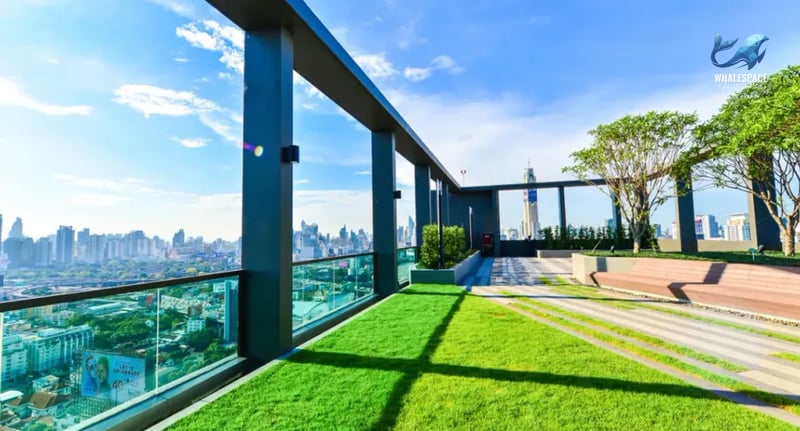Expansive rooftop terrace with manicured lawns, seating areas, and panoramic city views.