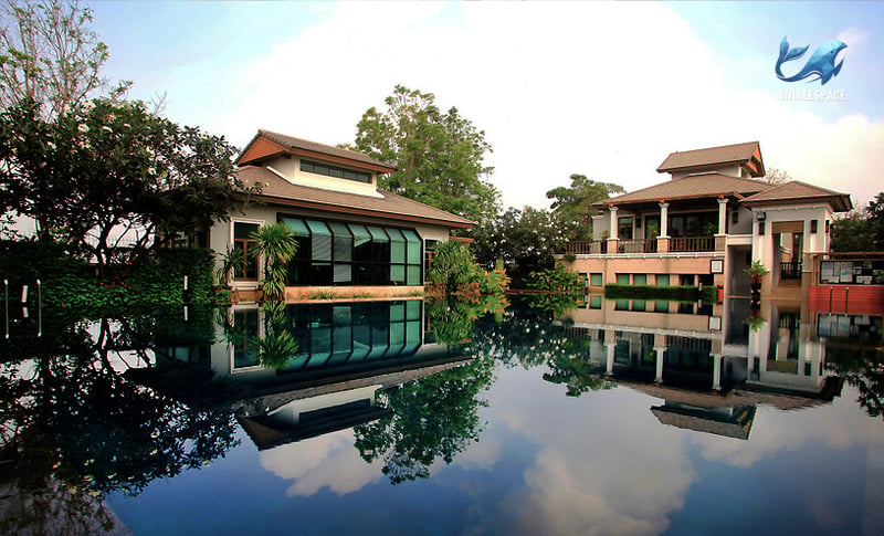 Expansive swimming pool reflecting the sky and surrounding architecture, with a clear view of the buildings.