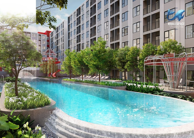 Large outdoor swimming pool with waterfall features, a kids' play area, and lush green landscaping