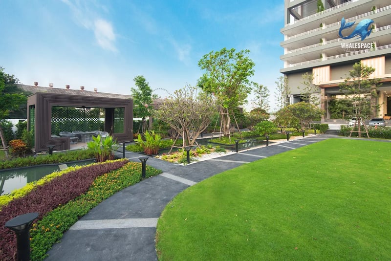 Manicured ground-level garden with walking paths, diverse plant life, and a modern wooden gazebo for relaxation.