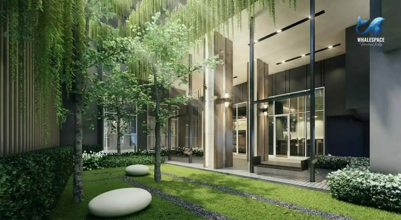 Lush green garden space with trees and seating areas, adjacent to the building's entrance.