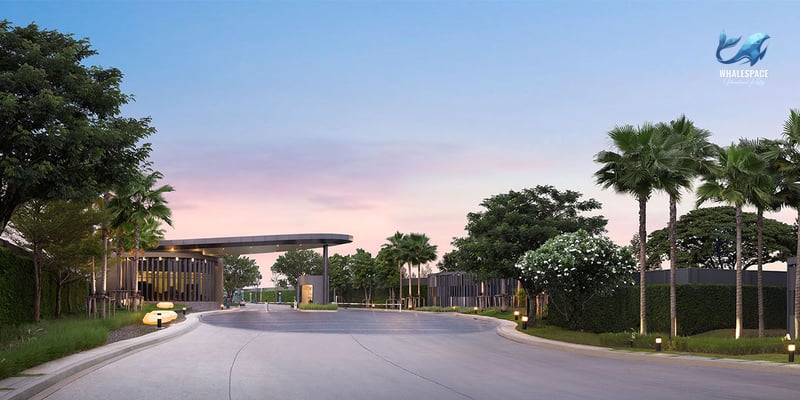 Grand entrance to a residential project featuring a modern archway, manicured trees, and soft ambient lighting.