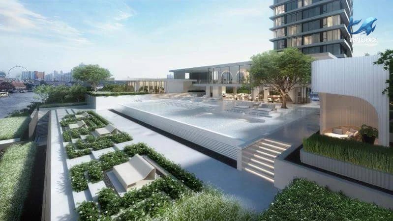 Expansive swimming pool area with lush landscaping and river view.