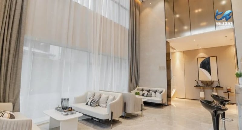 Elegant high-ceiling lobby featuring plush seating, contemporary art, and sophisticated lighting for a grand welcome.
