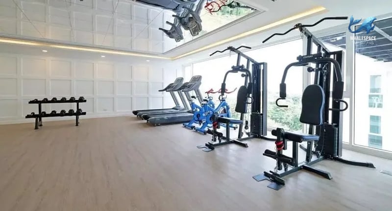Well-equipped fitness center with treadmills, weight machines, and dumbbells