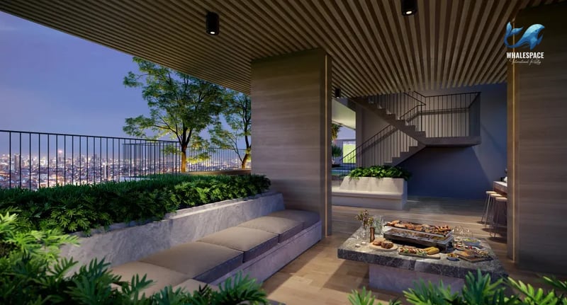 Covered outdoor lounge area with comfortable seating and a BBQ setup, overlooking the city.
