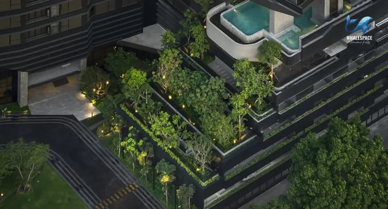 Aerial view of a meticulously landscaped garden with mature trees, water features, and integrated lighting.