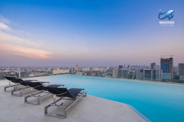 Infinity swimming pool with city view and lounge chairs