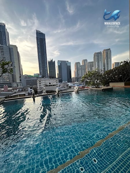 Infinity pool overlooking a cityscape with modern skyscrapers.