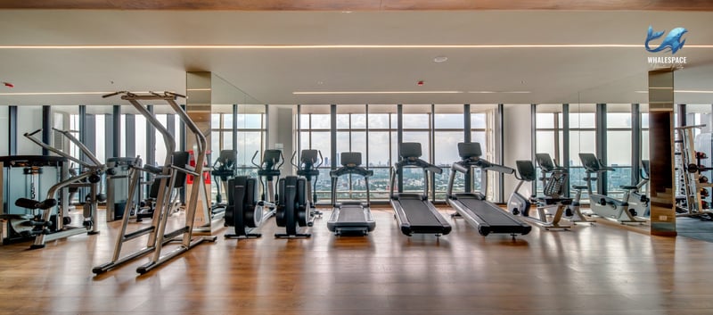 Well-equipped fitness center with treadmills, ellipticals, and weight machines overlooking the city