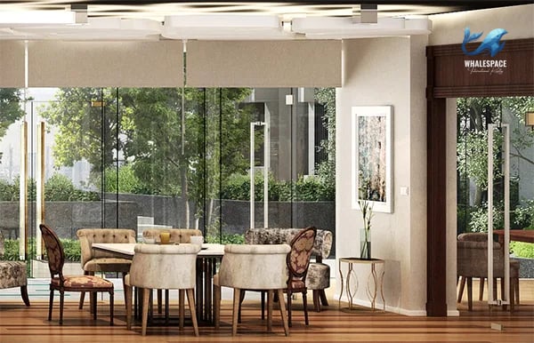 Elegant resident dining area with upholstered chairs, round tables, and floor-to-ceiling windows overlooking a garden.