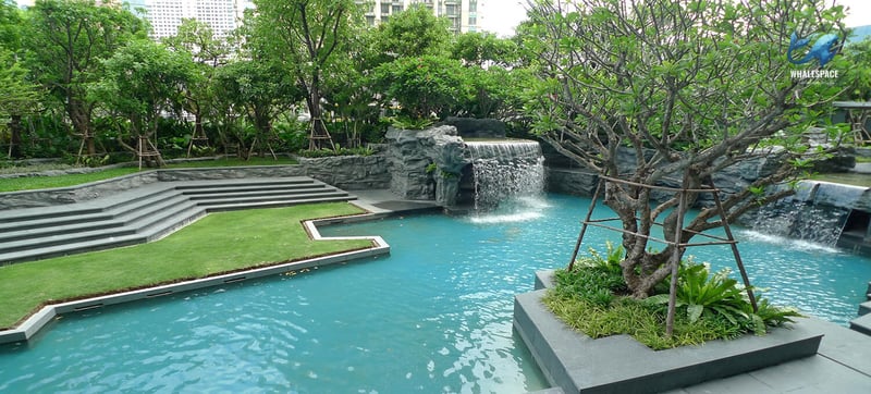 Cascading water features and lush landscaping around an outdoor pool area